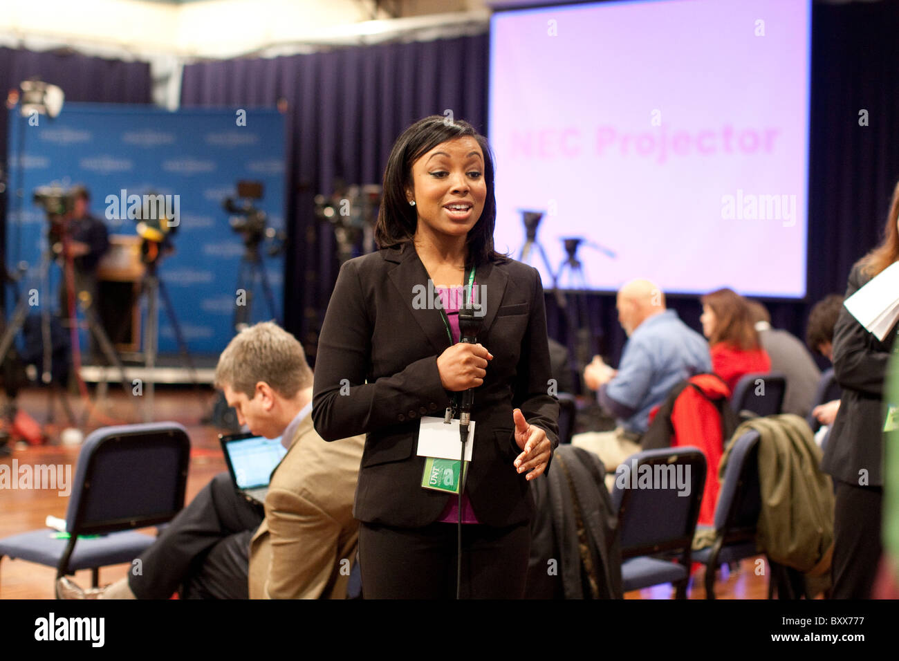 Weibliche African American TV-News-Reporter Mikrofon hält und spricht in die Kamera während der Kandidaten-Debatte in Texas Stockfoto
