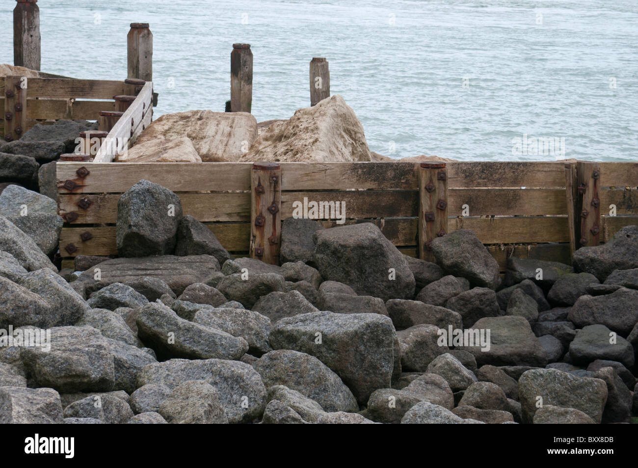 Meer-Verteidigung und Schutz Felsbrocken und Zaun Stockfoto