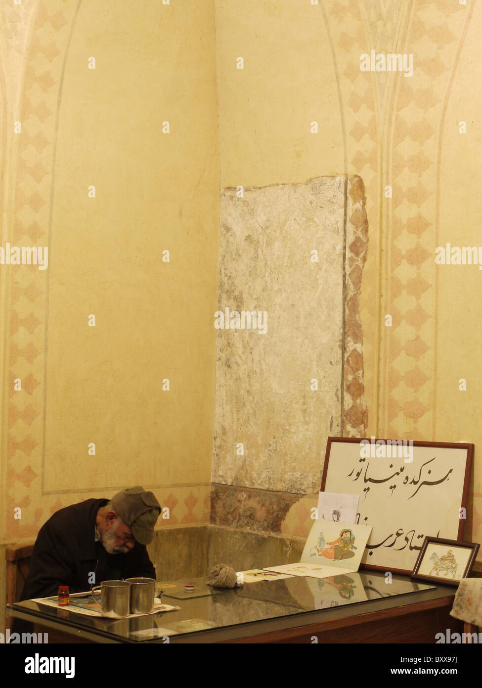 Mann schläft auf seinem Schreibtisch in einem umgebauten Raum Hamman-e Vakil, Shiraz, Iran Stockfoto