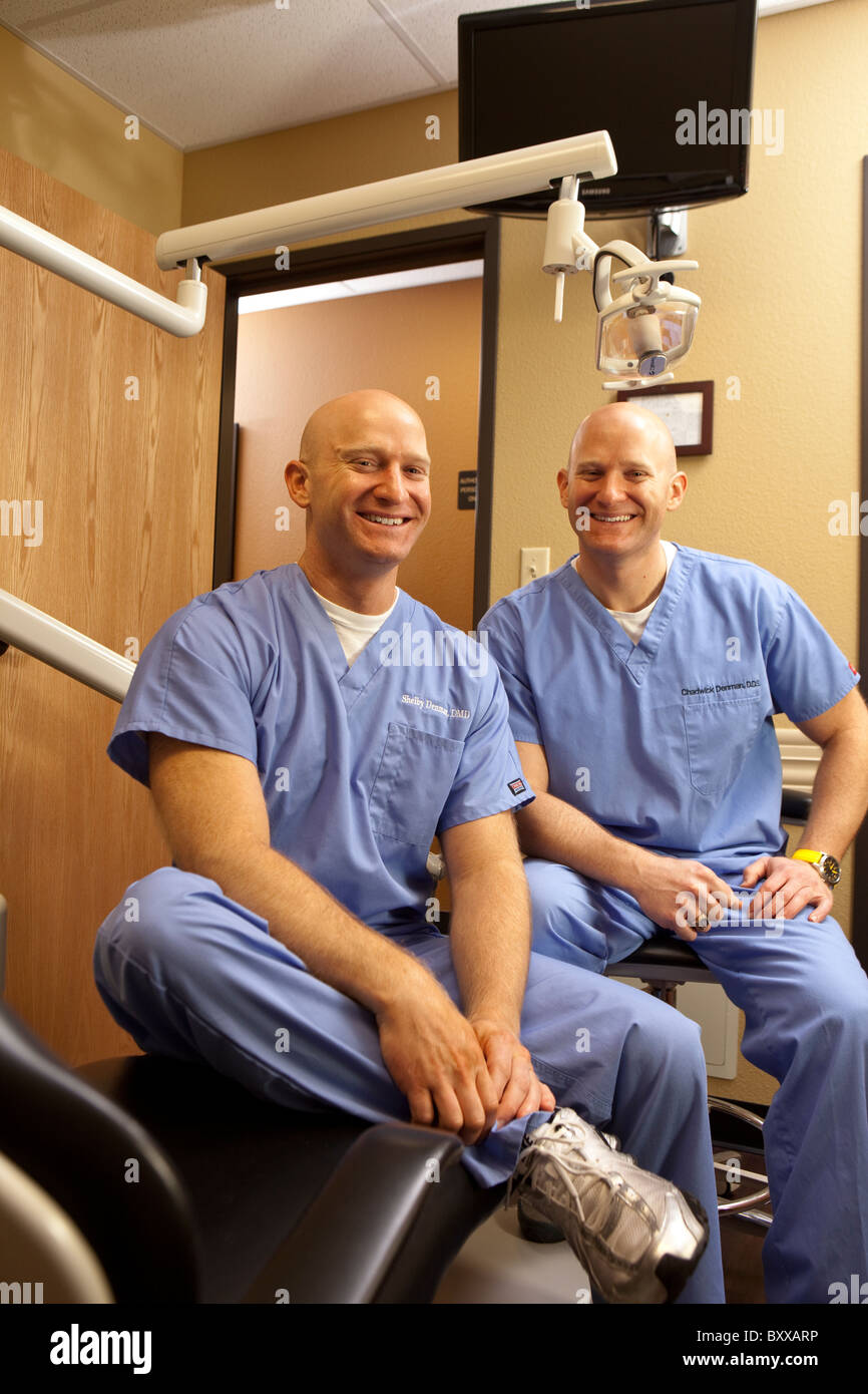 Zahnärzte, die eineiigen Zwillinge sind stellen in einem Untersuchungsrichter Raum in der Klinik, wo sie zusammen in Austin, Texas USA ausüben. Stockfoto