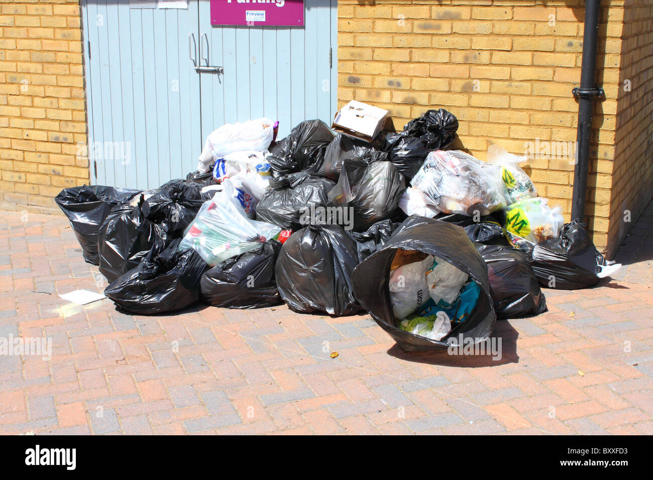Nicht abgeholte Müllsäcke in hoher Dichte lebenden Lage in Canterbury, Kent, England Stockfoto