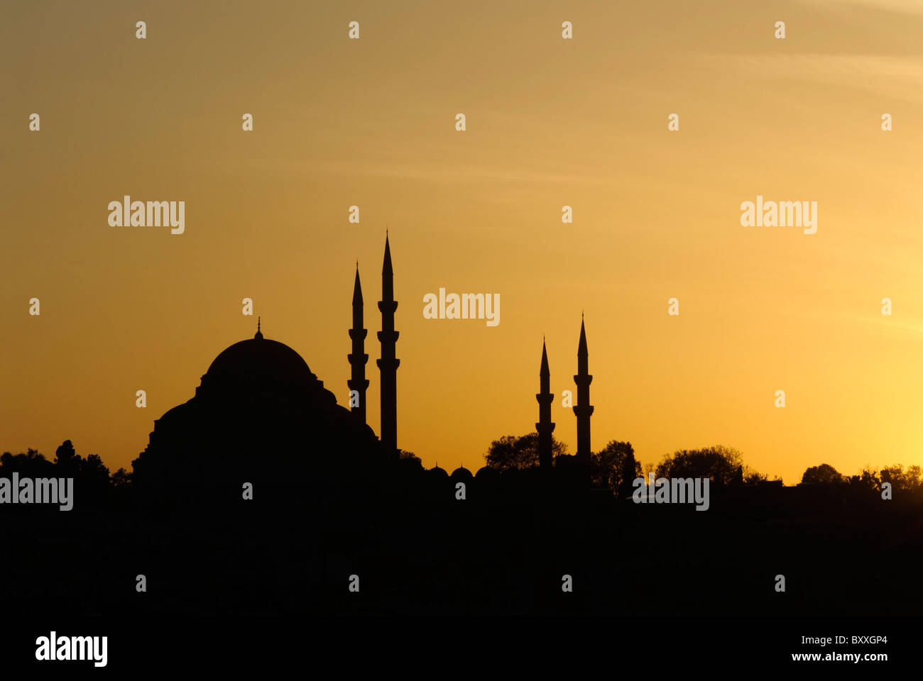 Süleymaniye Moschee Silhouette Istanbul Türkei // ISTANBUL, Türkei — Silhouette der Süleymaniye Camii (Süleymaniye Moschee) in Istanbul, Türkei. Die große Moschee und ihre Minarette zeichnen sich durch einen leuchtenden goldenen und orangen Himmel aus, während die untergehende Sonne ein warmes Leuchten ausstrahlt. Stockfoto