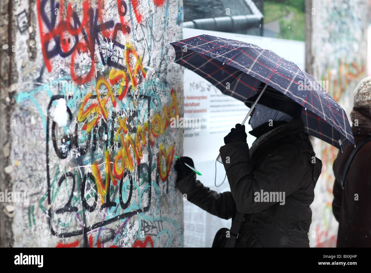 Ein Blick auf einige Touristen erhalten Teile der Berliner Mauer am Potsdamer Platz in Berlin, Deutschland. Stockfoto