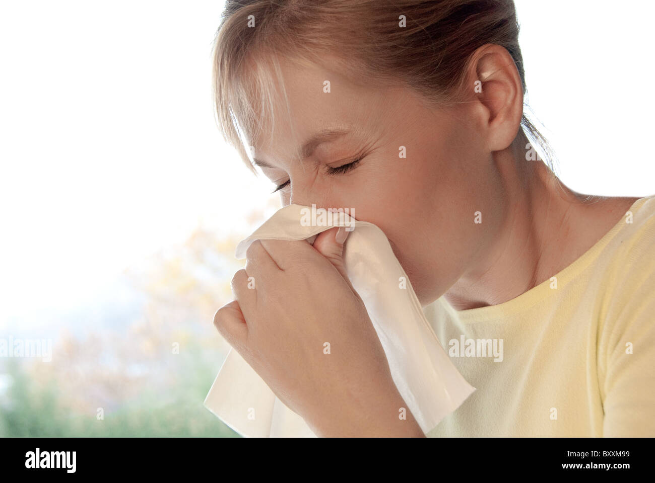 Frau mit einem Tuch um ihre Nase putzen Stockfoto