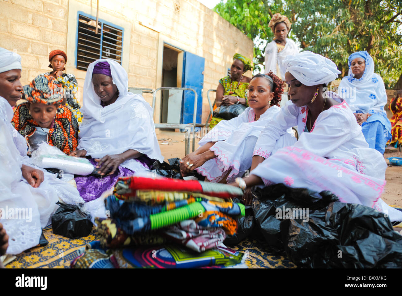 In Ouagadougou, Burkina Faso, bringen Frauen gaben der Kleidung zur Taufe eines Kindes. Stockfoto