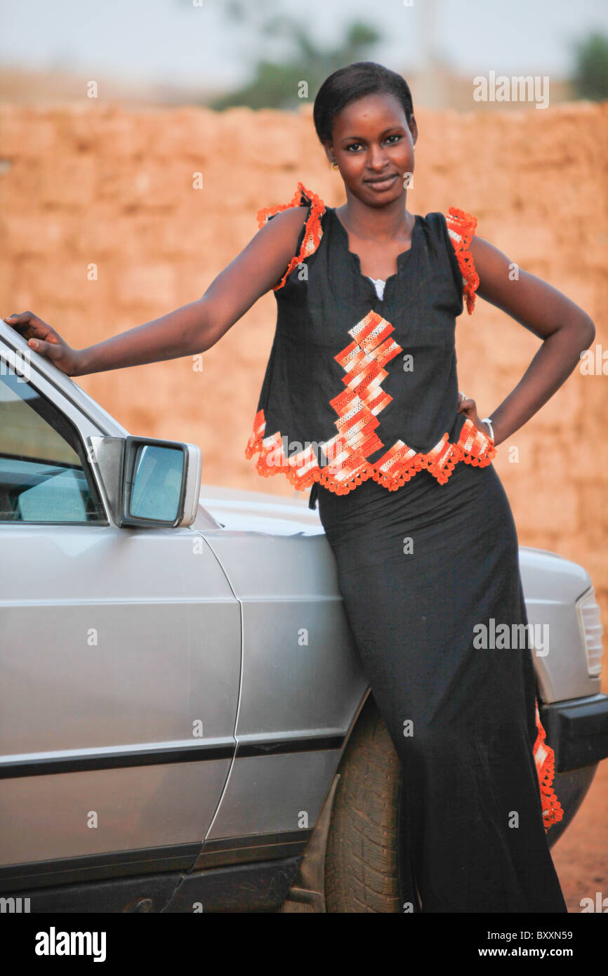 Eine Fulbe-Frau im nördlichen Burkina Faso zeigt zeitgenössische Bekleidungstrends. Stockfoto