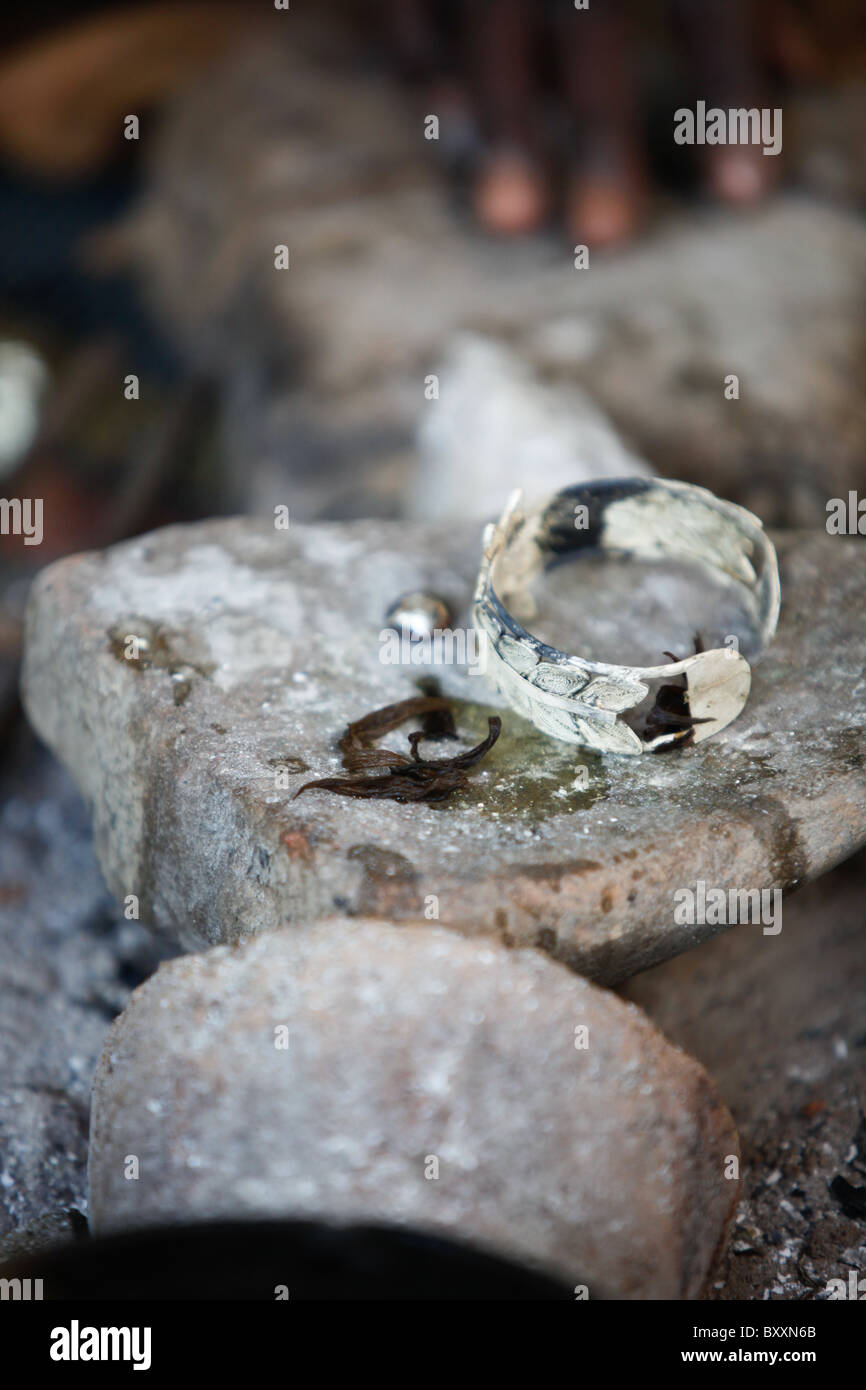 In des Schmieds im Dorf Bourro im Norden Burkina Faso liegt ein silbernes Armband im Arbeitsbereich. Stockfoto