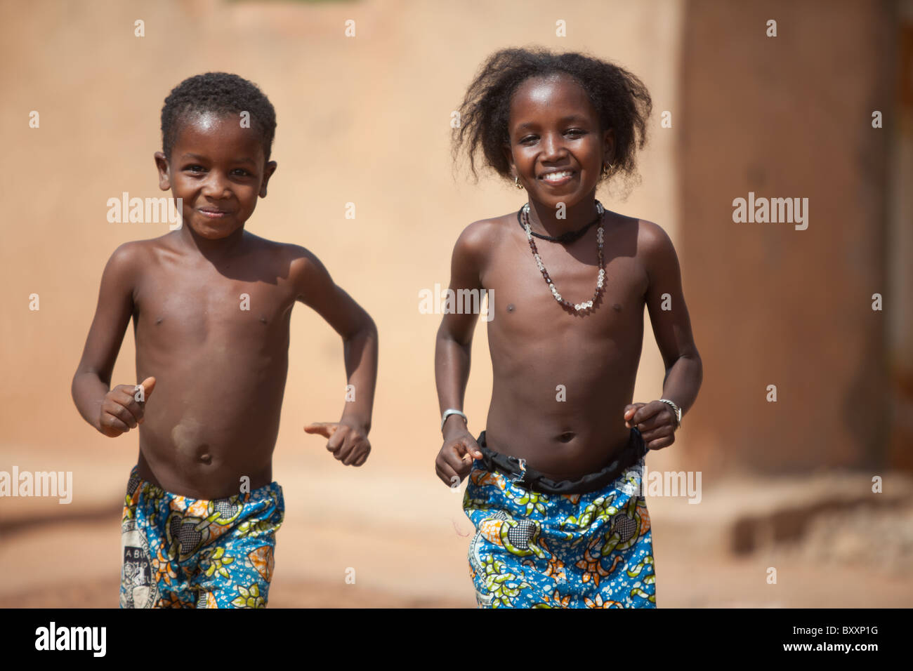 Zwei Fulani Kinder laufen in Richtung der Kamera in Djibo im nördlichen Burkina Faso. Stockfoto