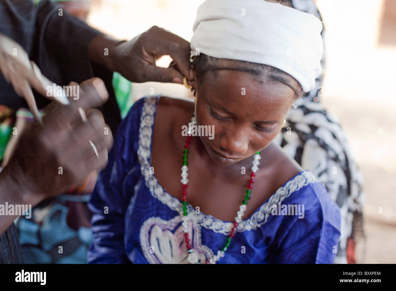 Nach Erhalt der goldene Ohrringe von ihrem Vater, besucht eine junge Frau den Schmied in Djibo, Burkina Faso für die "Montage". Stockfoto