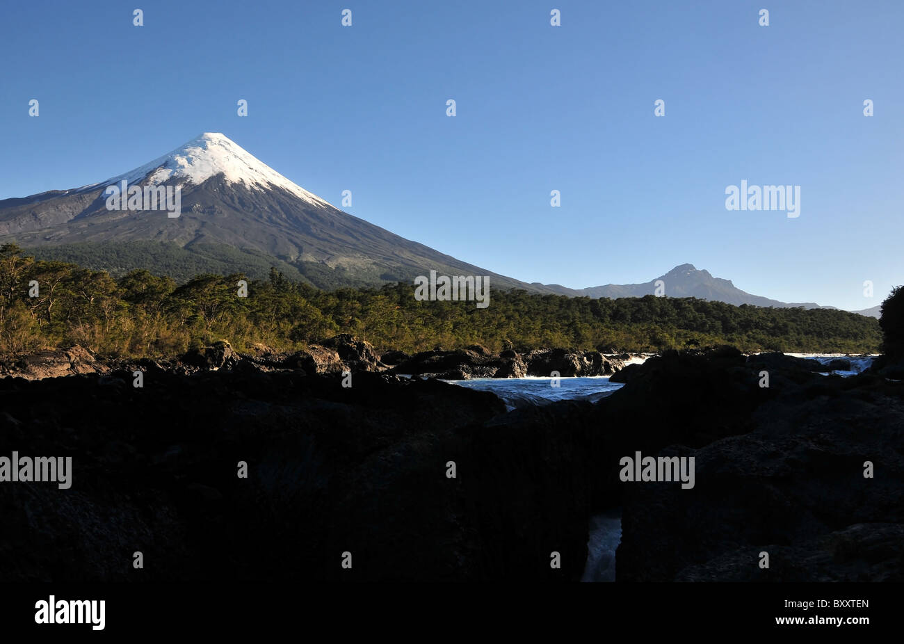 Blauen Himmel am Morgen auf den Petrohue Wasserfall mit dem Eis Kegel von Volcan Osorno erhebt sich über gemäßigten Regenwald, Chile Stockfoto