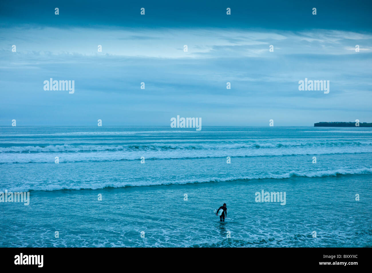 Eineileisigen Surfer unter Ceruleshimmel verlassen die Brandung bei Flut im Strandresort Lahinch (Lehinch) in der Dämmerung, Grafschaft Clare, Westküste von Irland Stockfoto