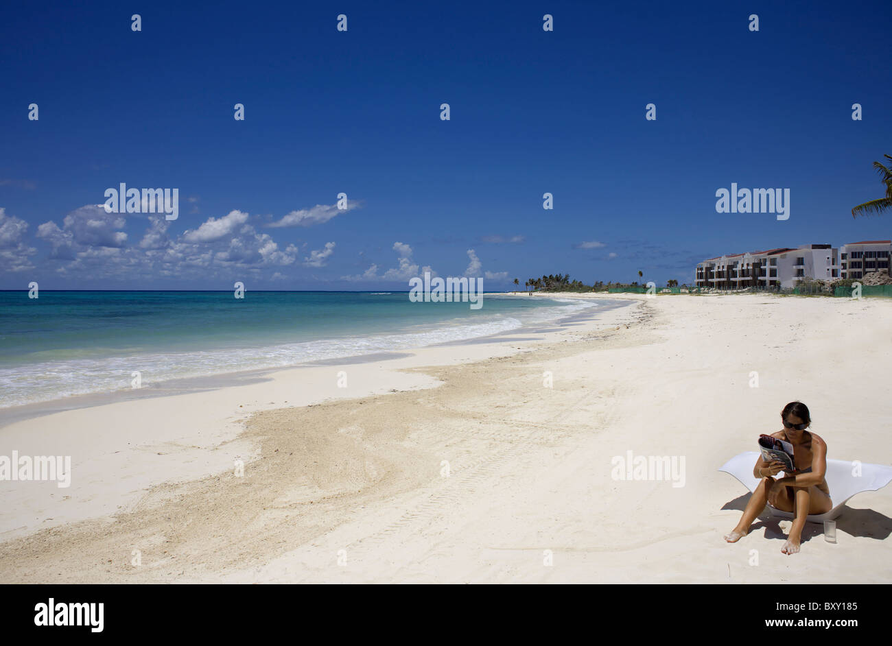 Junge Frau sitzend am Strand Lesen einer Zeitschrift, Riviera Maya, Quintana Roo, Halbinsel Yucatán, Mexiko, Yucatan, Sommer, Sonne, Stockfoto