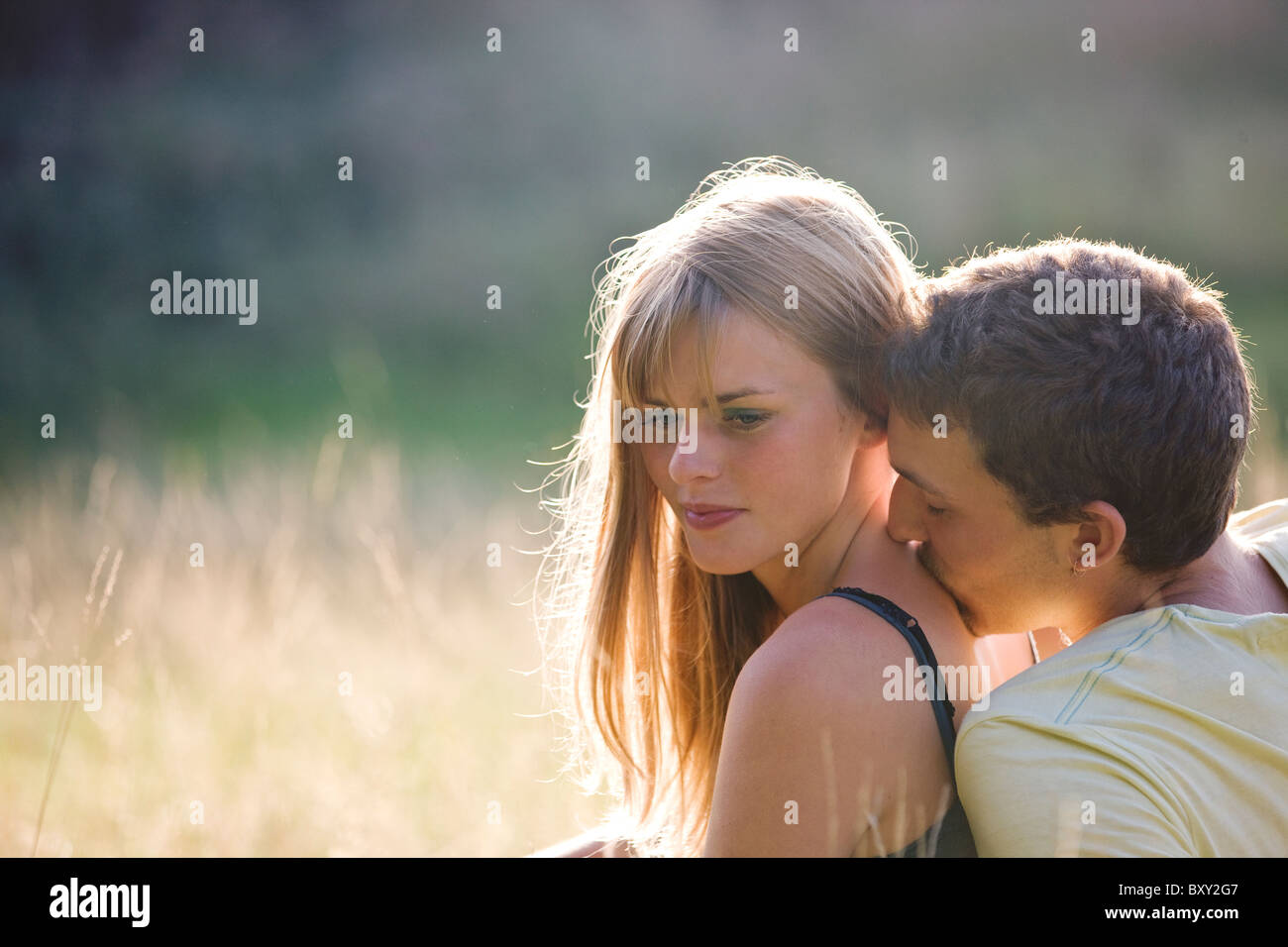 Ein junges Paar im freien Mann küssen Womans Hals Stockfoto