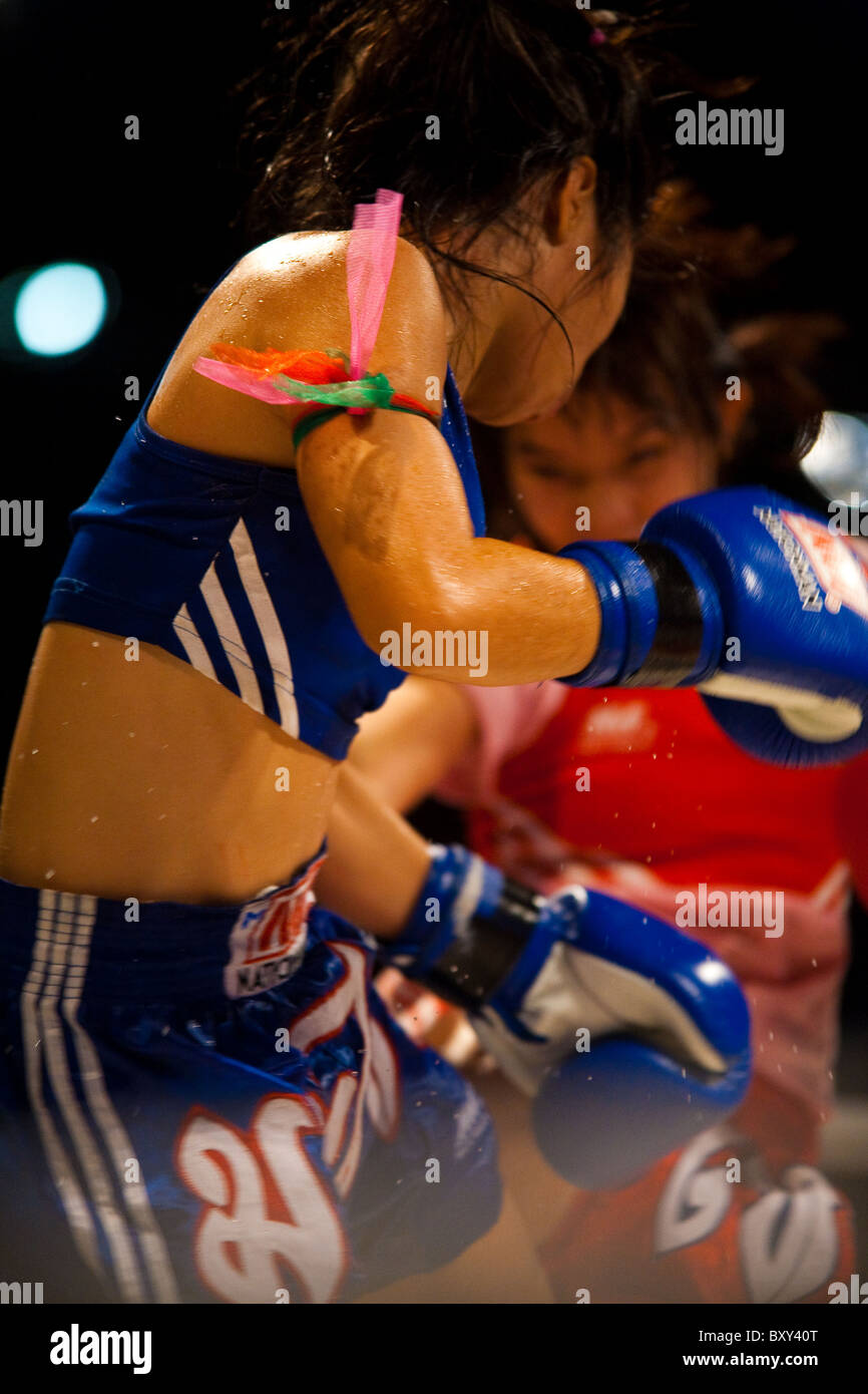 Asiatische Frau Muay-thai-Boxer Kick Schweiß fliegen bei Amateur Damen Kickboxen Match senden empfangen Stockfoto