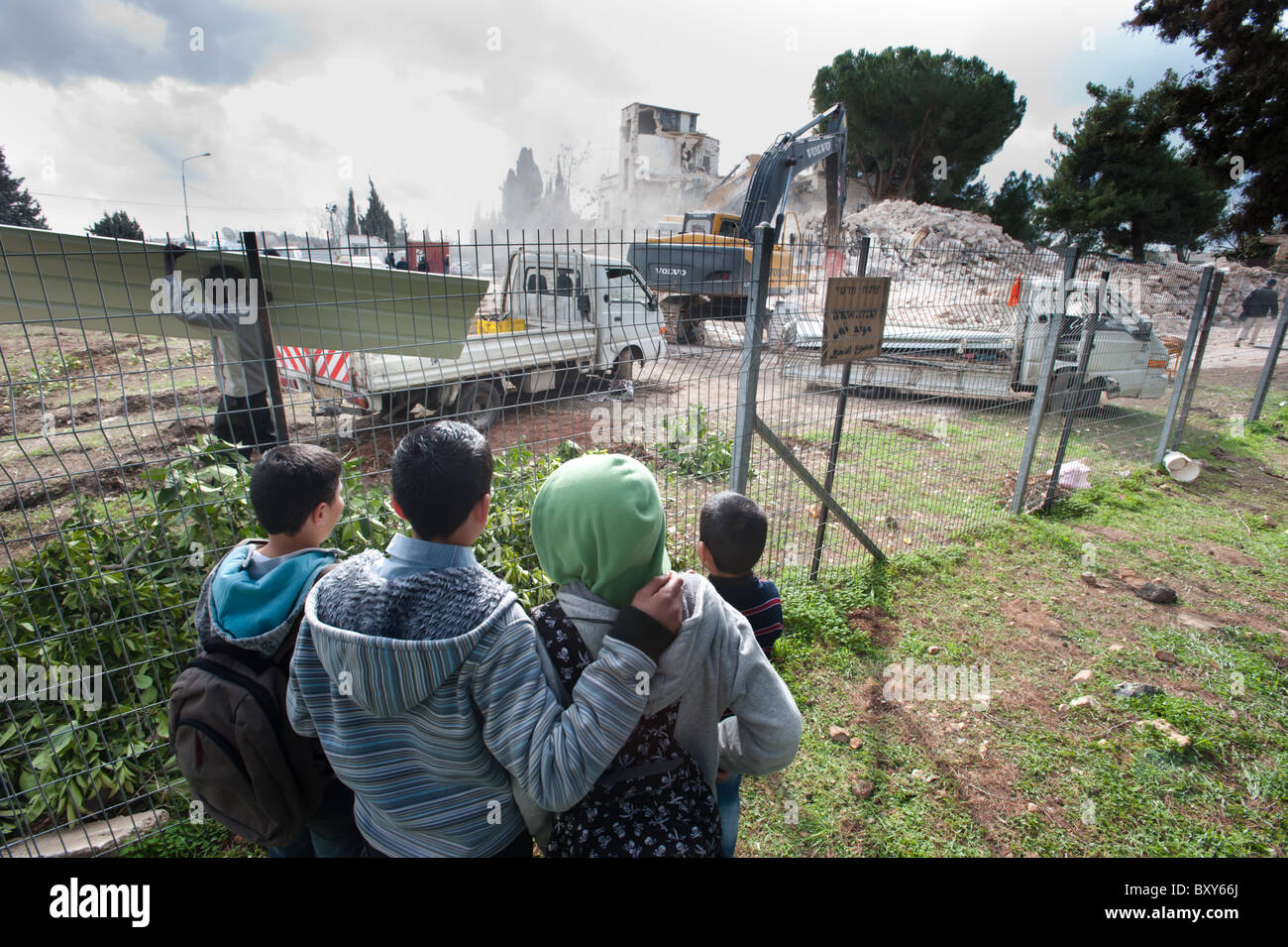 Palästinensische Kinder beobachten israelischen Auftraggeber Gebäude um Platz für neue jüdische Siedlungen in Ost-Jerusalem zu zerstören. Stockfoto