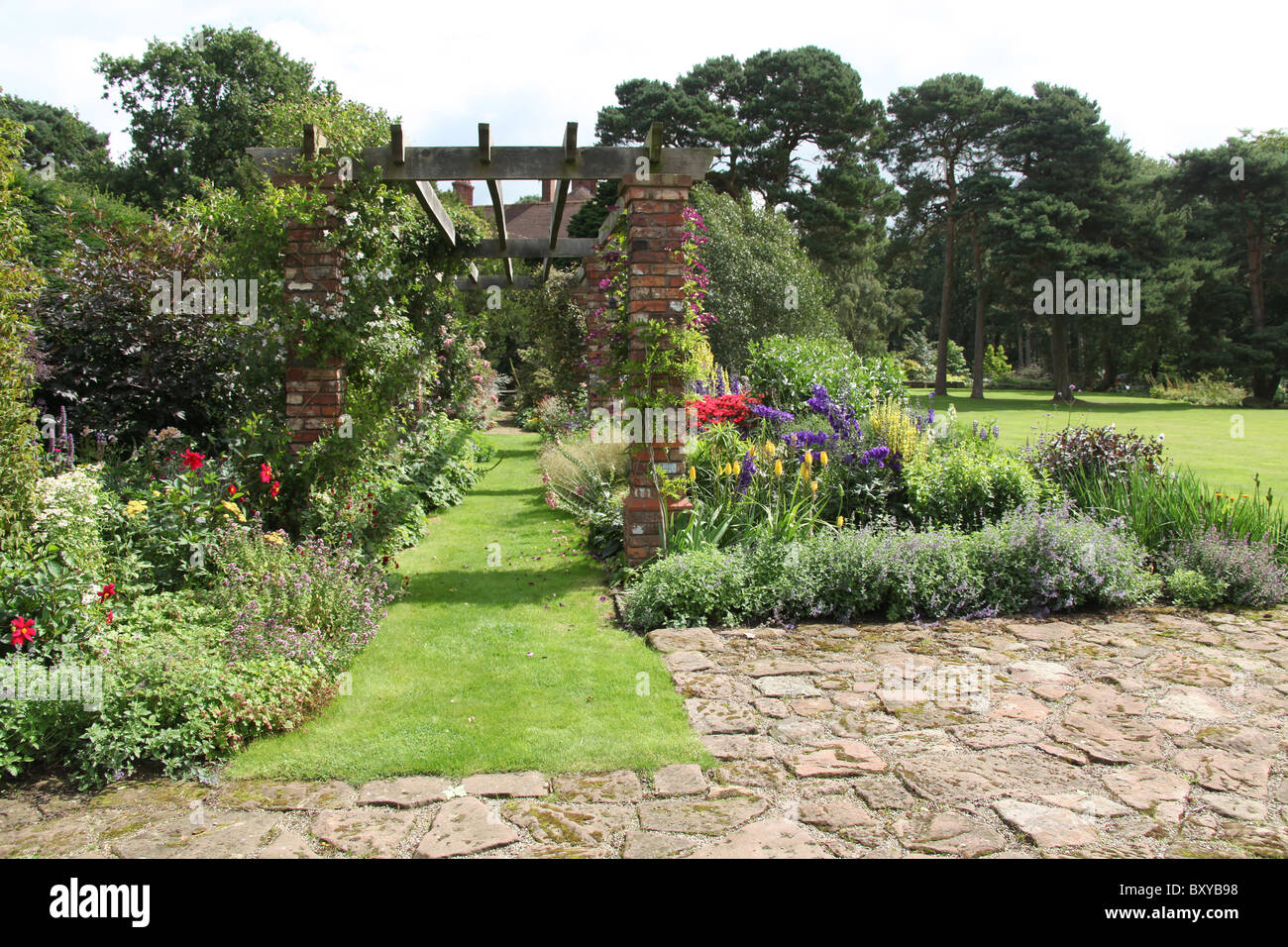 Abbeywood Garten, Cheshire. Malerische Sommer Ansicht der krautige Grenze innerhalb des Gartens Abbeywood Pergola Fuß. Stockfoto