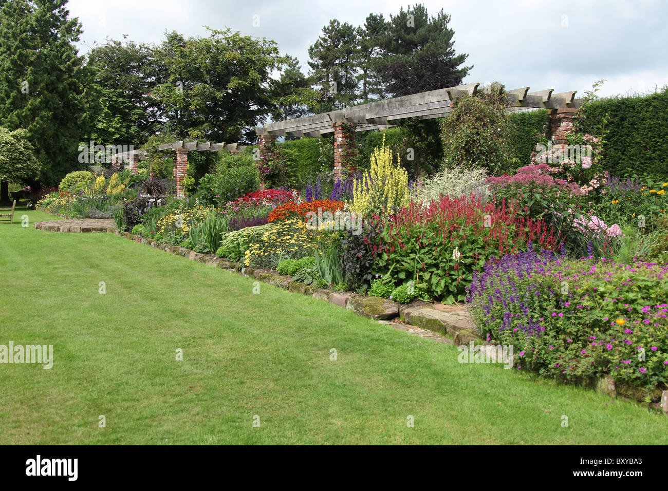 Abbeywood Garten, Cheshire. Malerische Sommer Ansicht der krautige Grenze innerhalb des Gartens Abbeywood Pergola Fuß. Stockfoto