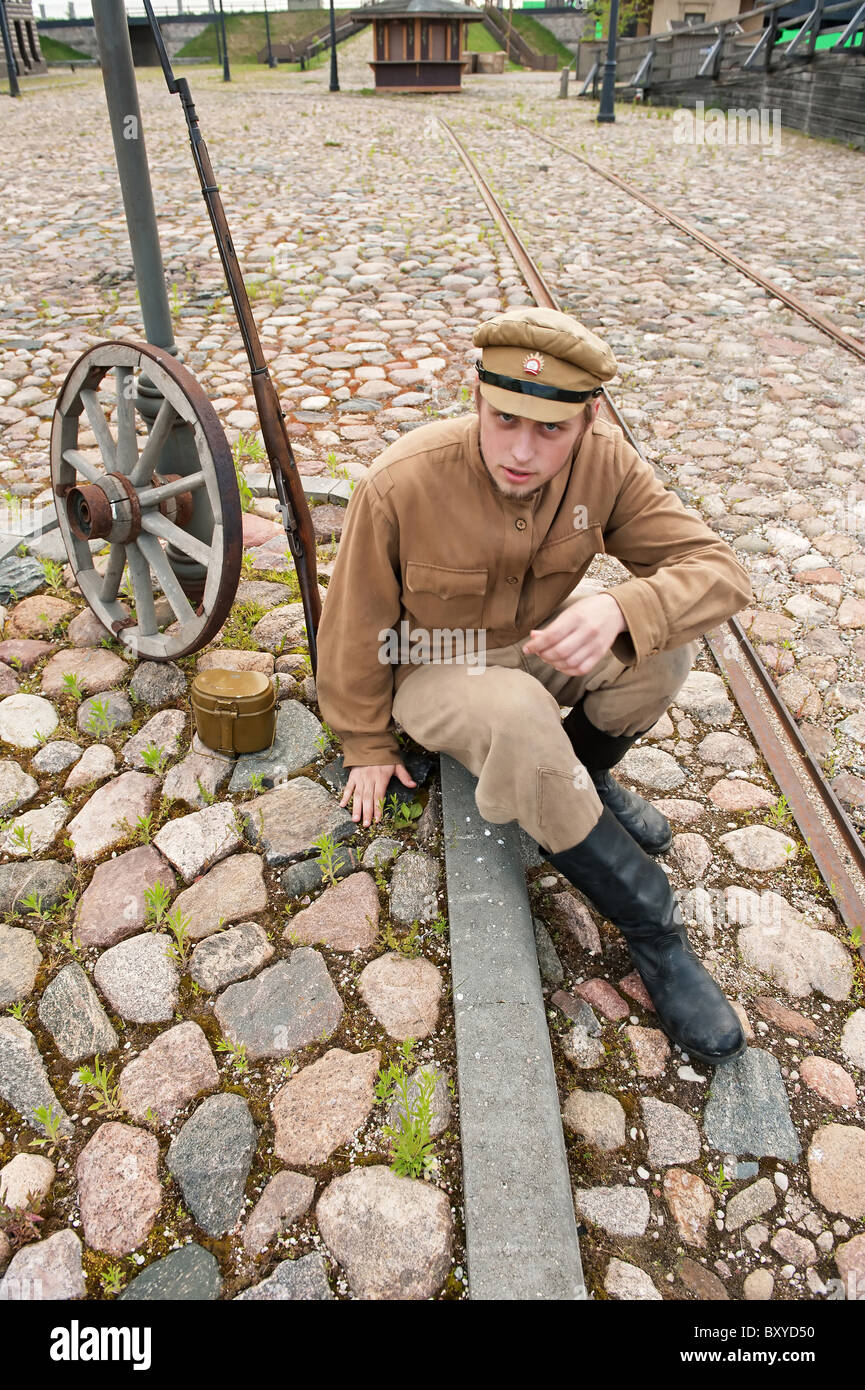 Soldat in Uniform des ersten Weltkrieges, hinsetzen, ruht auf dem Bürgersteig und Rauchen. Kostüm Accord Zeiten Weltkrieg I. Foto Stockfoto