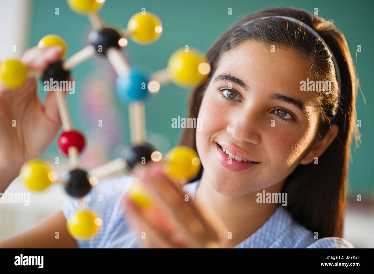 Schulmädchen Blick auf Molekülmodell Stockfoto