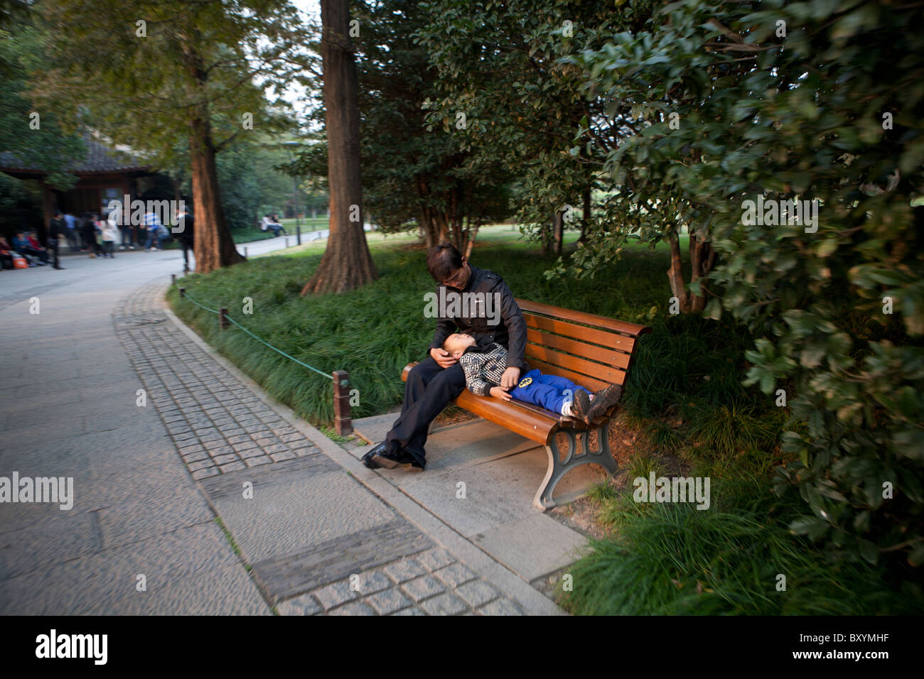 Mann mit seinem Kind Schlaf in einem Park Hangzhou, China Stockfoto