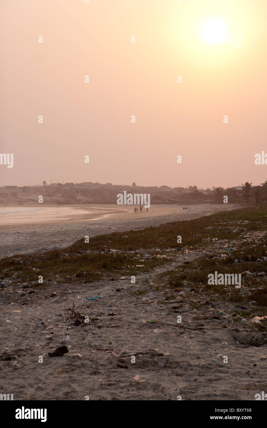 Die Sonne geht auf einem teilweise verschmutzten Strand am zentralen Küste Ghanas. Stockfoto