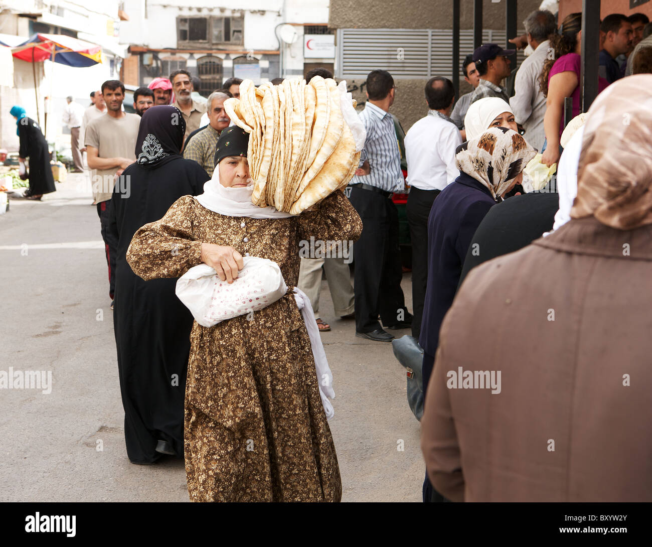 Syrische Frau, die frisch gebackene Fladenbrote außerhalb einer Backstreet-Bäckerei in der alten Stadt von Damaskus, Syrien Stockfoto