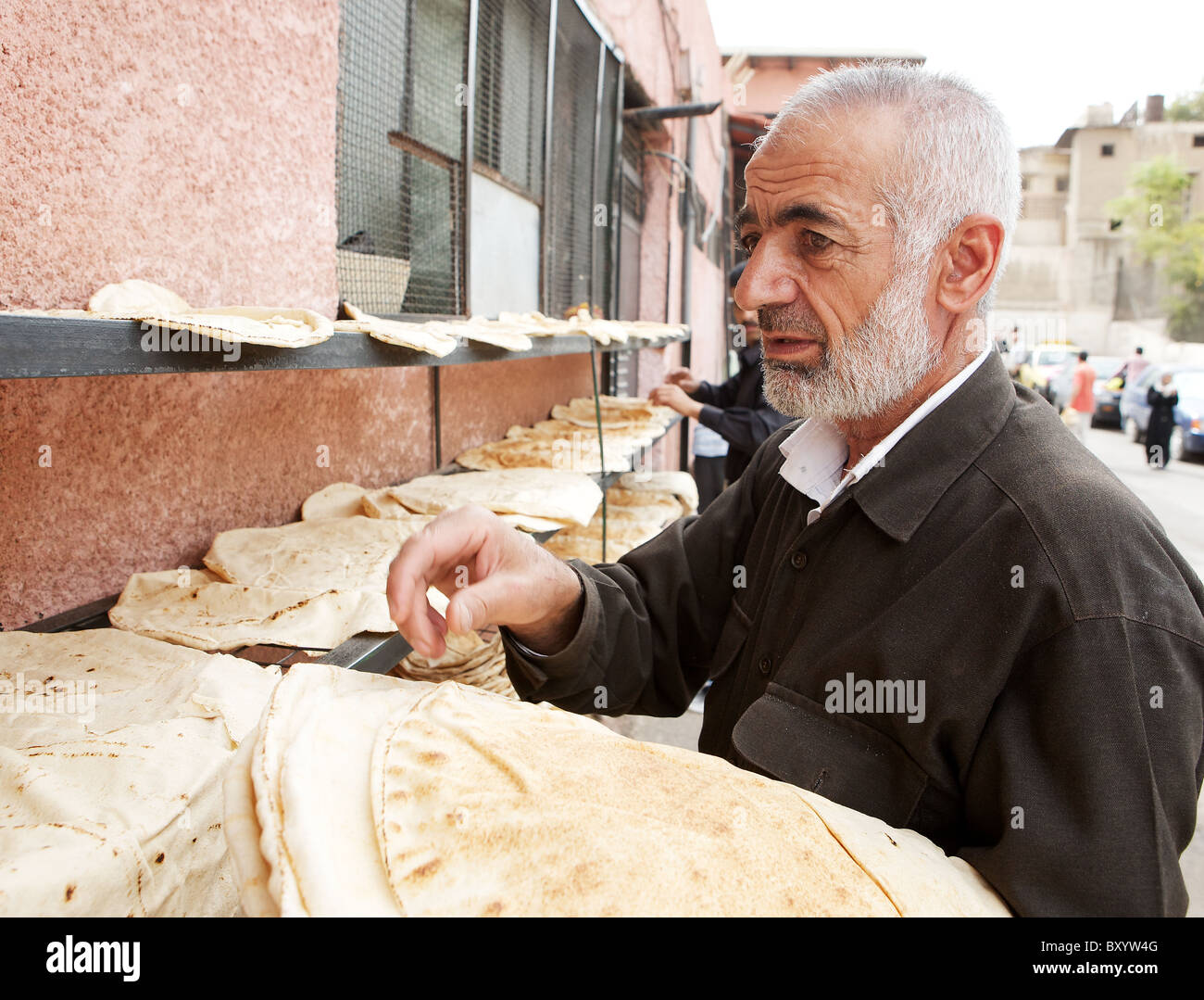 Syrischen Mann trocknen frisch gebackenen Wohnung-Brot außerhalb einer Backstreet-Bäckerei in der alten Stadt von Damaskus, Syrien Stockfoto
