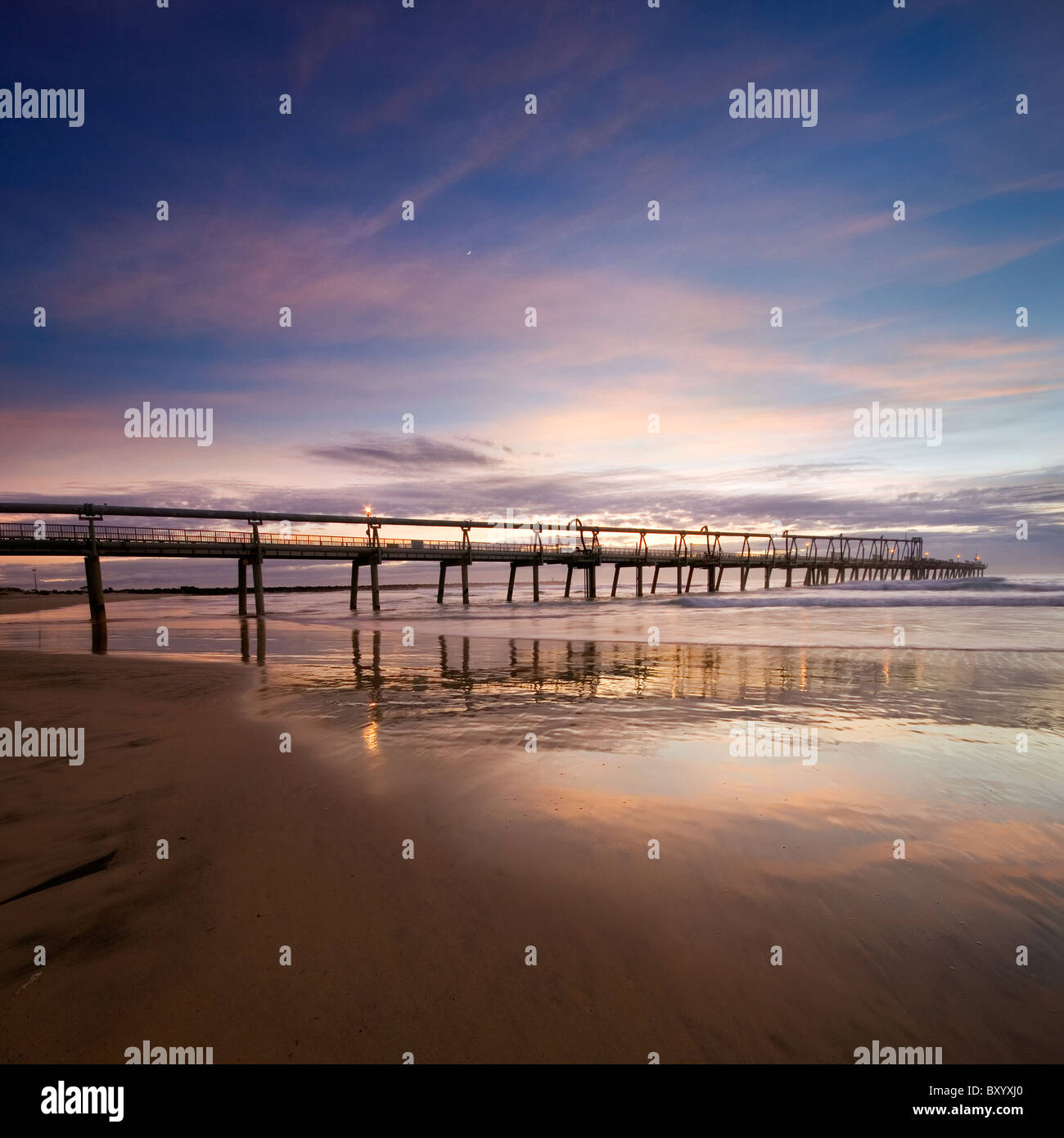 Pier in der Morgendämmerung mit interessante Reflexionen und glatte Wolken-Bildung im quadratischen format Stockfoto