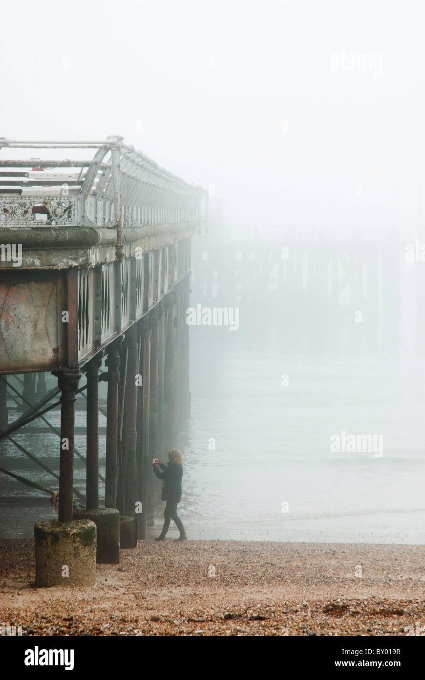 Frau allein mit dem Fotografieren von Pier Detail an nebeligen Tag Stockfoto