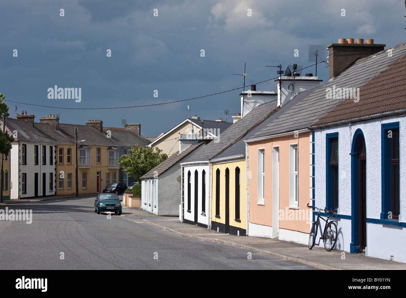 Straßenszene Pastell gemalt Reihenbungalows und Fahrrad in Kilkee, County Clare, Railway Road, westlich von Irland Stockfoto