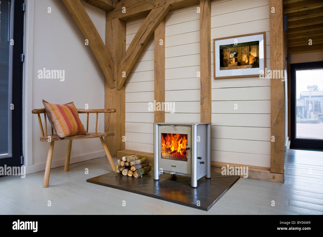Eine Esse Holzverbrennung Herd in einer Eiche gerahmt modernes Haus. Stockfoto