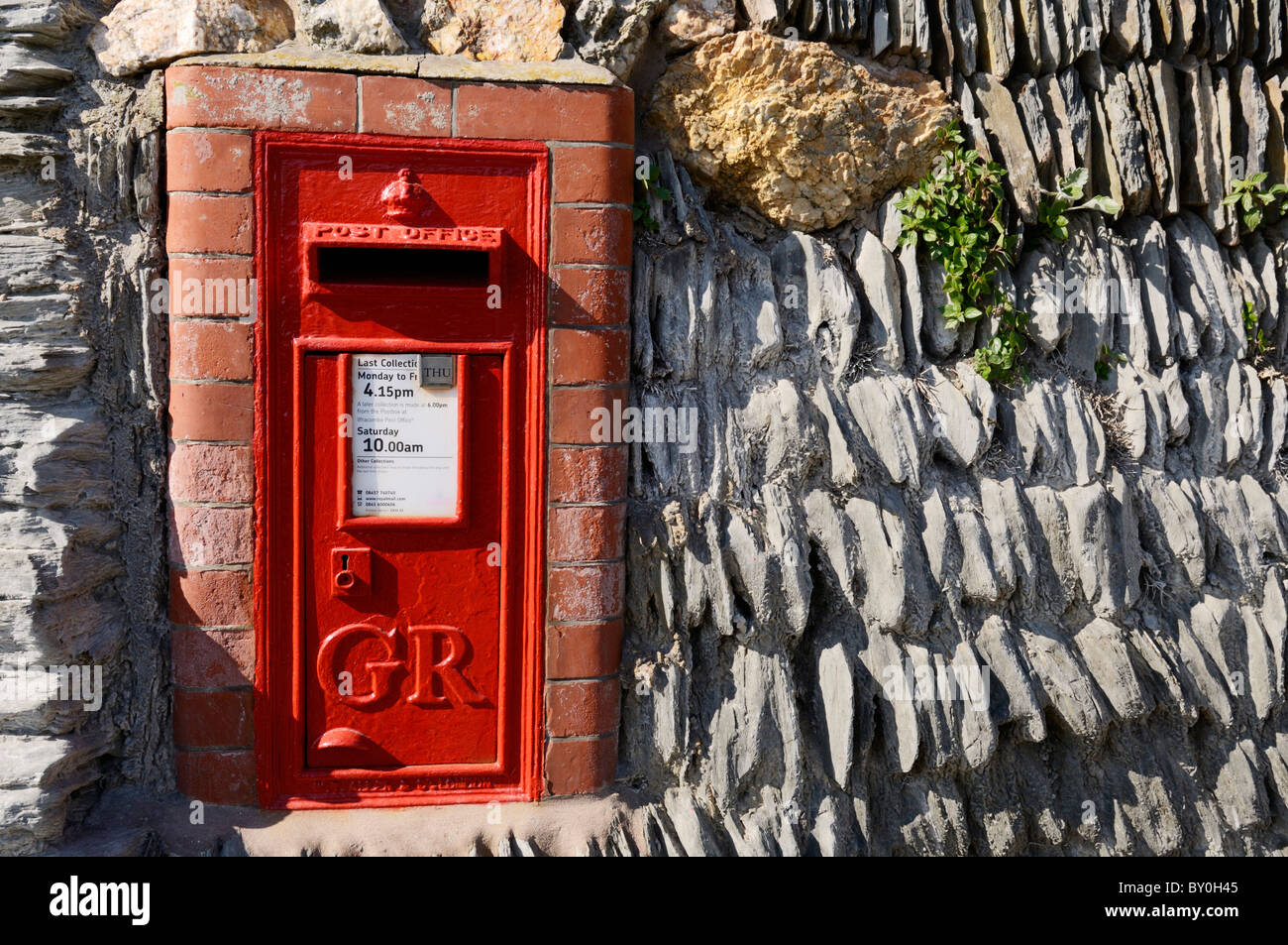 Eine traditionelle rote Pfostenpocken in einer Schieferwand in Mortehoe, Devon, England gebaut. Stockfoto