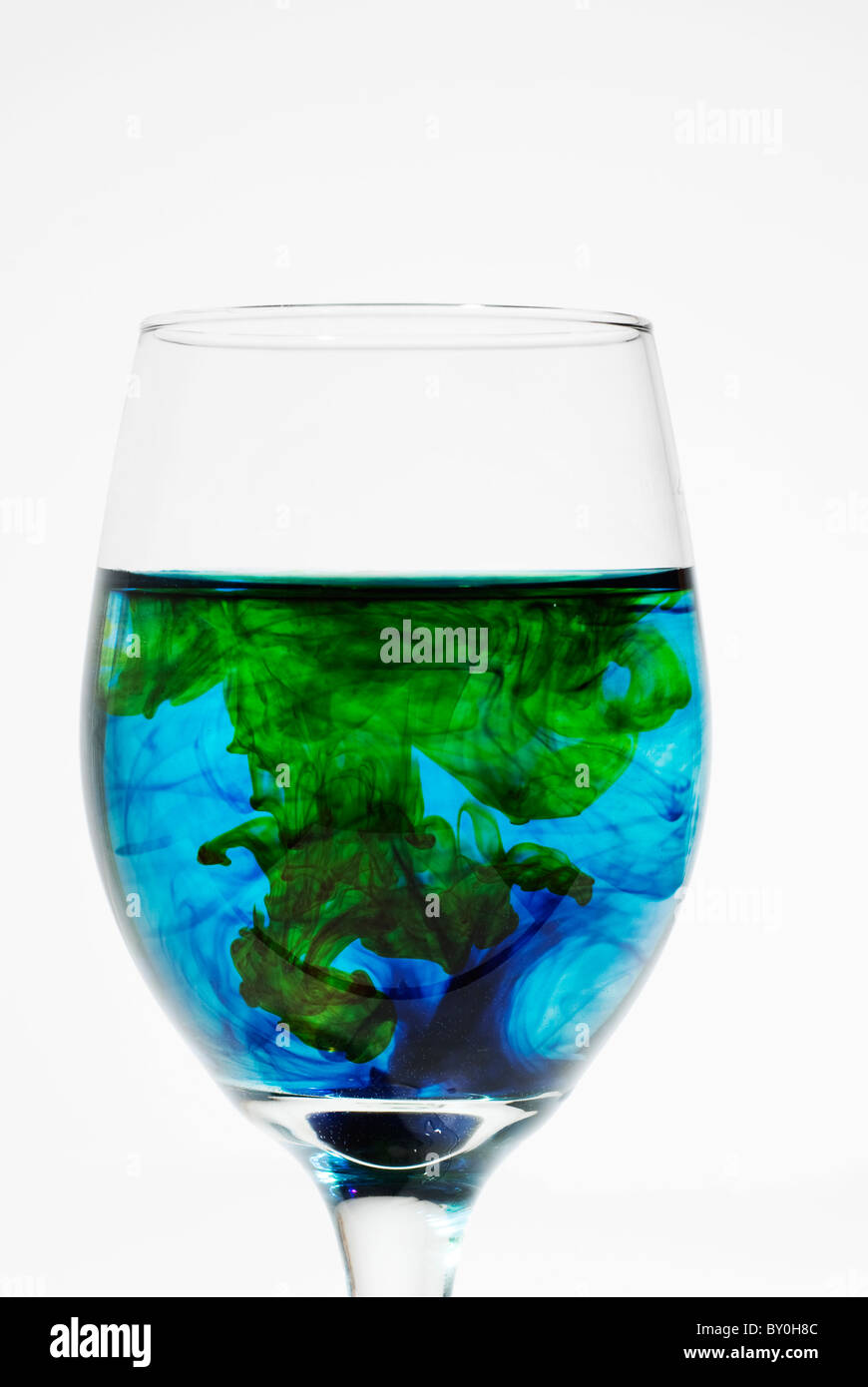 Lebensmittelfarbe wirbelte in Weinglas Stockfoto