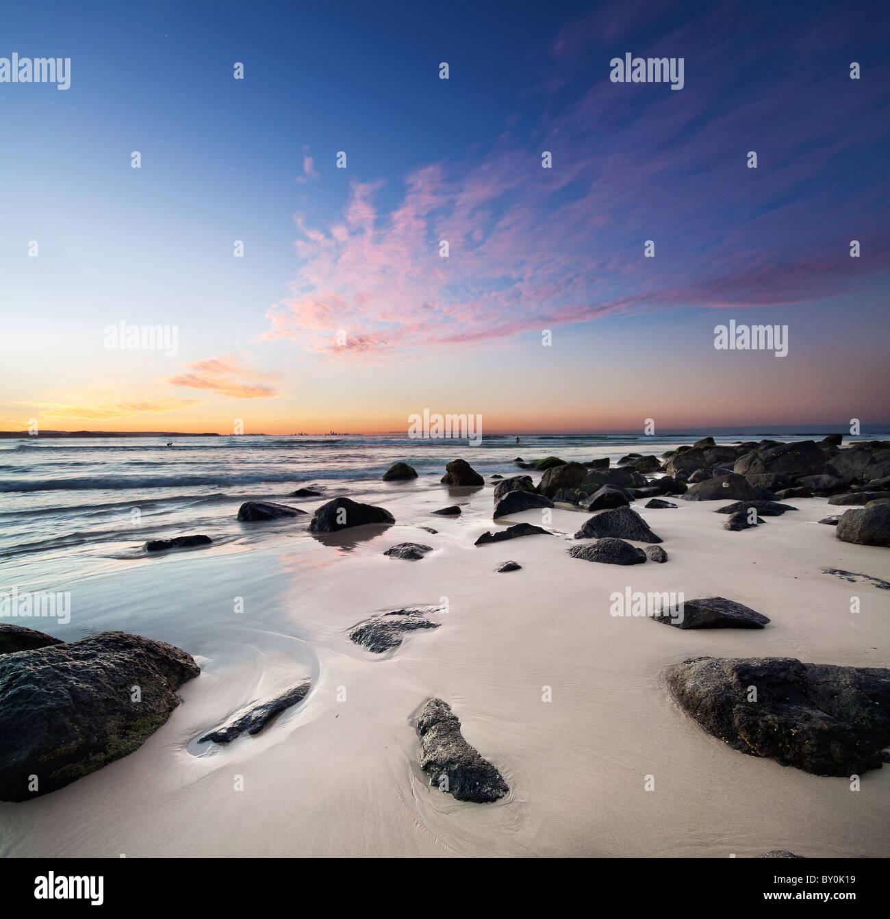 interessante Strand in der Abenddämmerung mit Felsen im Vordergrund Stockfoto