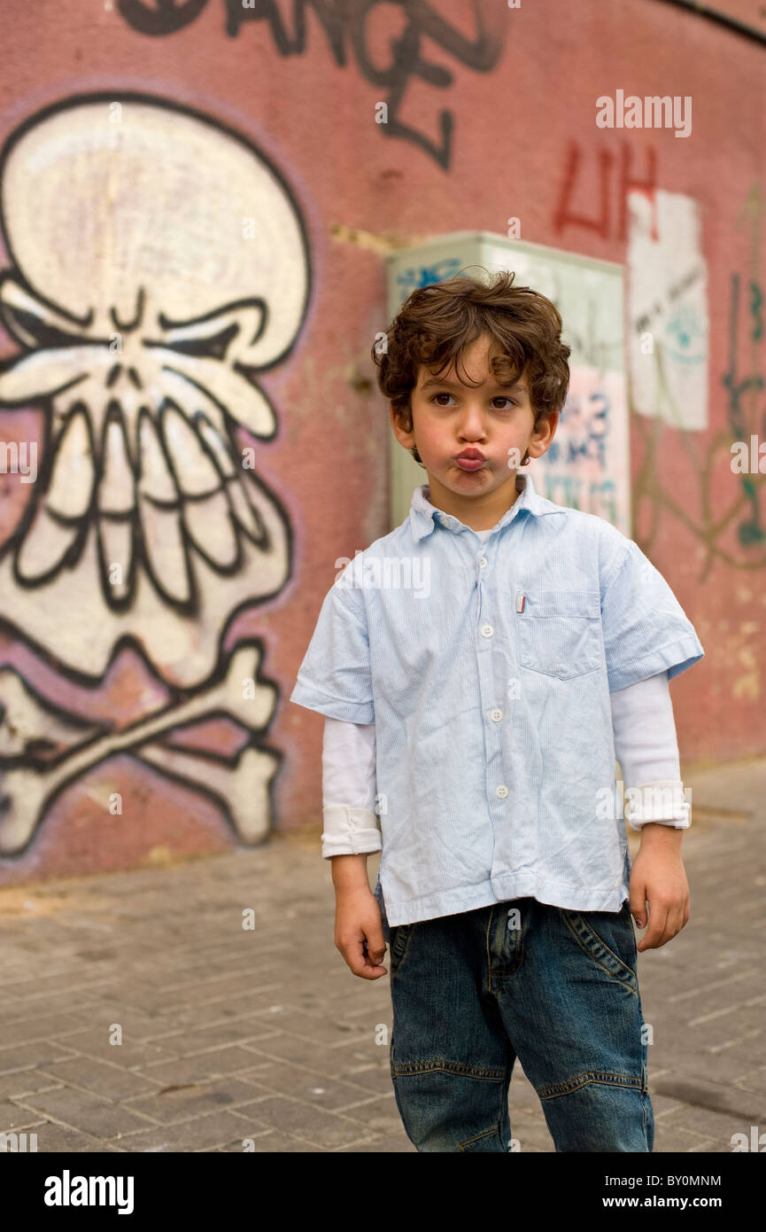 Porträt eines jungen Mannes vor einer Wand mit Graffiti eines Schädels Stockfoto