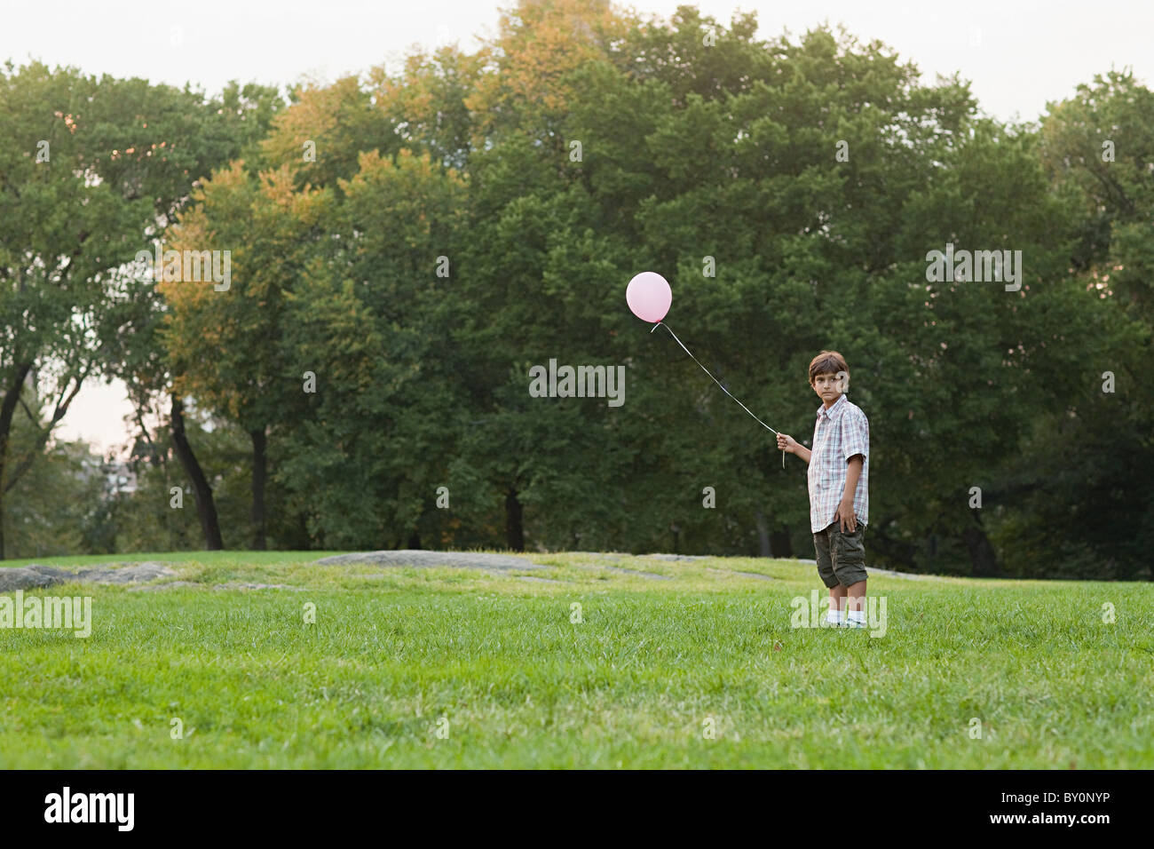 Junge am Geburtstag Party halten Ballon Stockfoto