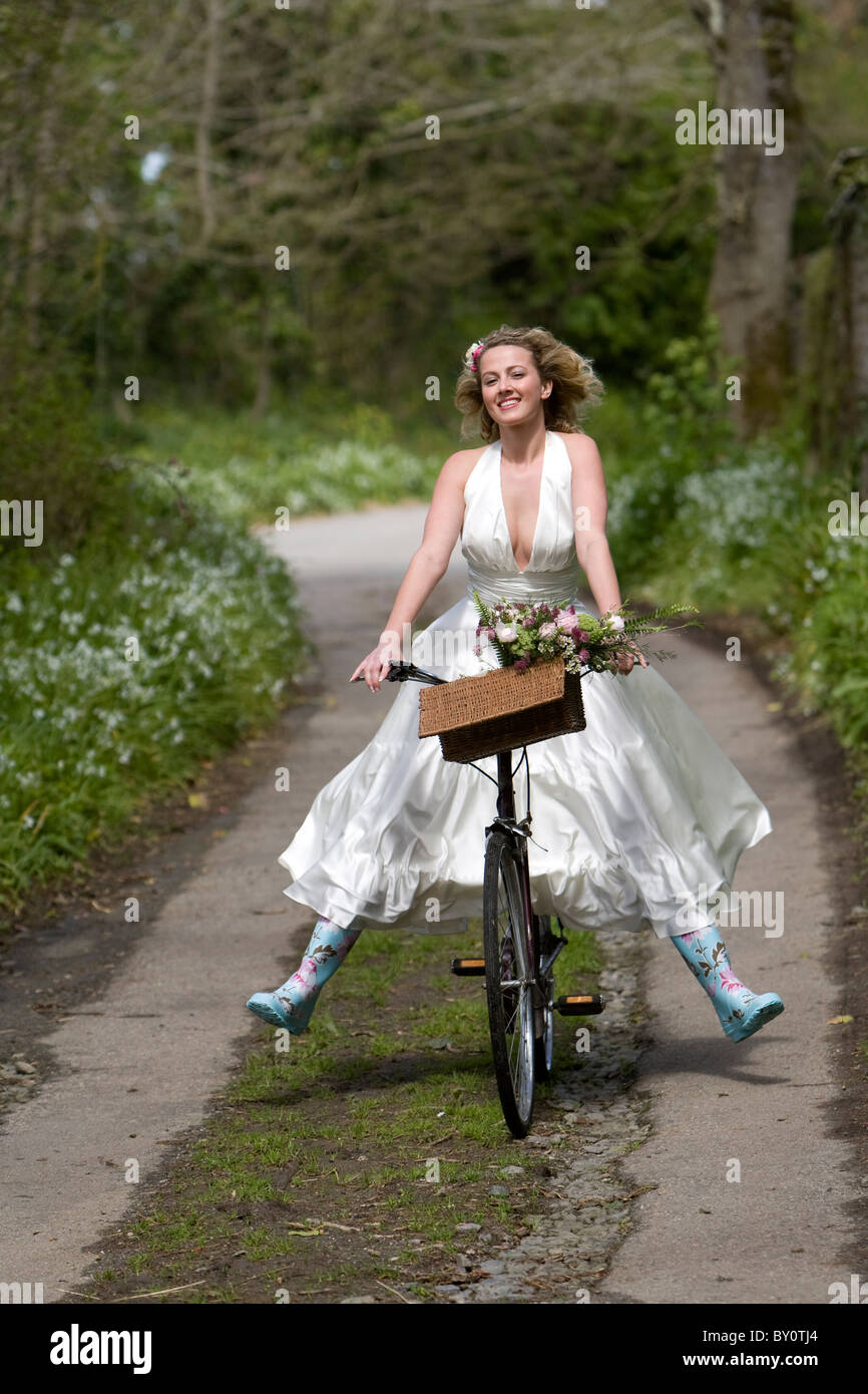 Ein Model posiert wie eine Braut, die mit dem Fahrrad tragen Gummistiefel  Stockfotografie - Alamy