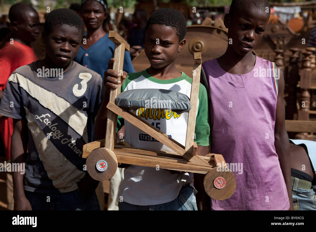 NAMPULA, Mosambik, Mai 2010: Sonntagsmarkt - Jungs, die ein Kind hölzernen vierrädrigen Roller zu verkaufen.    Foto: Mike Goldwater Stockfoto