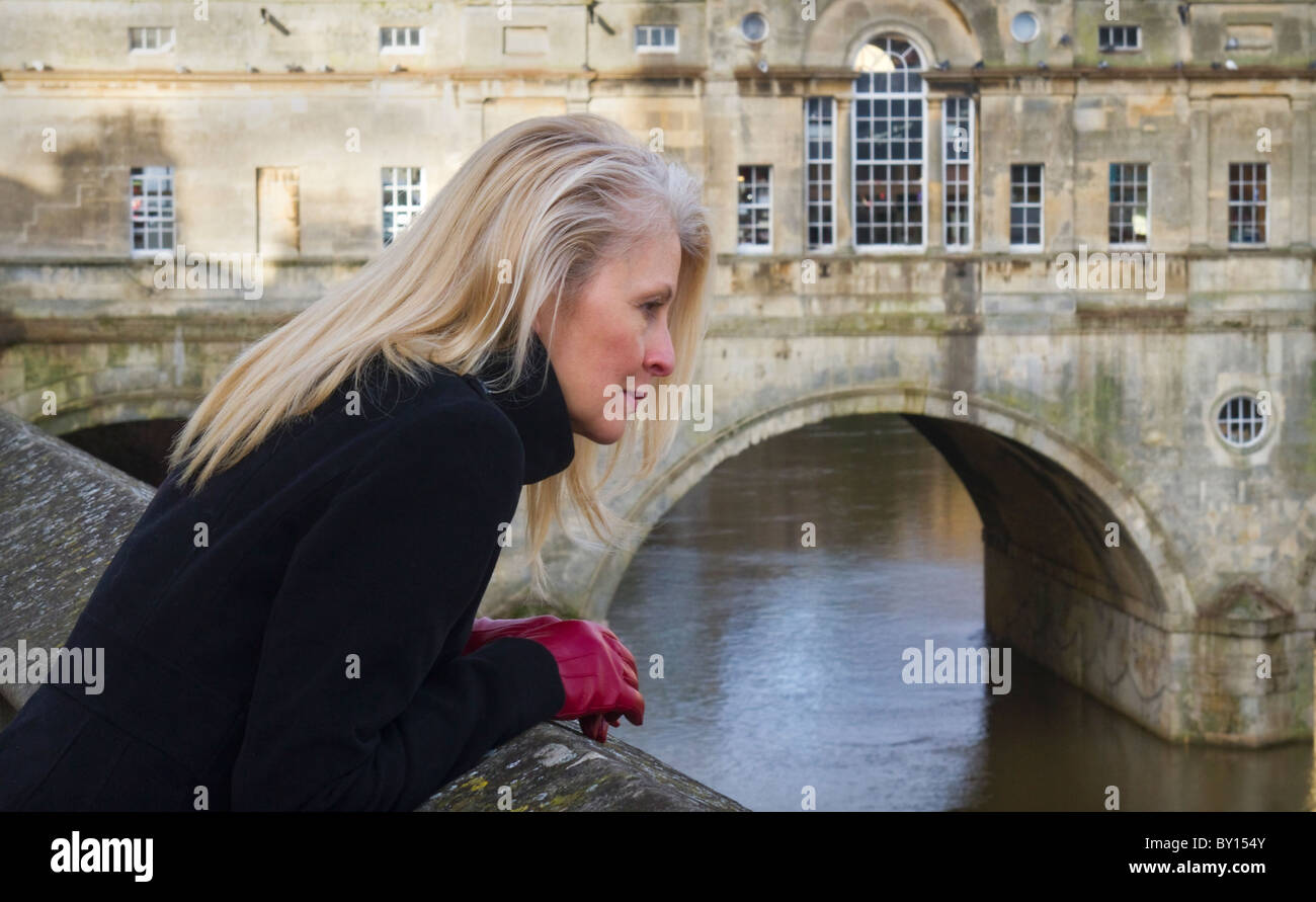 Eine Frau genießt die Aussicht über den Fluss Avon, Bath. Die berühmte Pultney Brücke ist im Hintergrund. Stockfoto