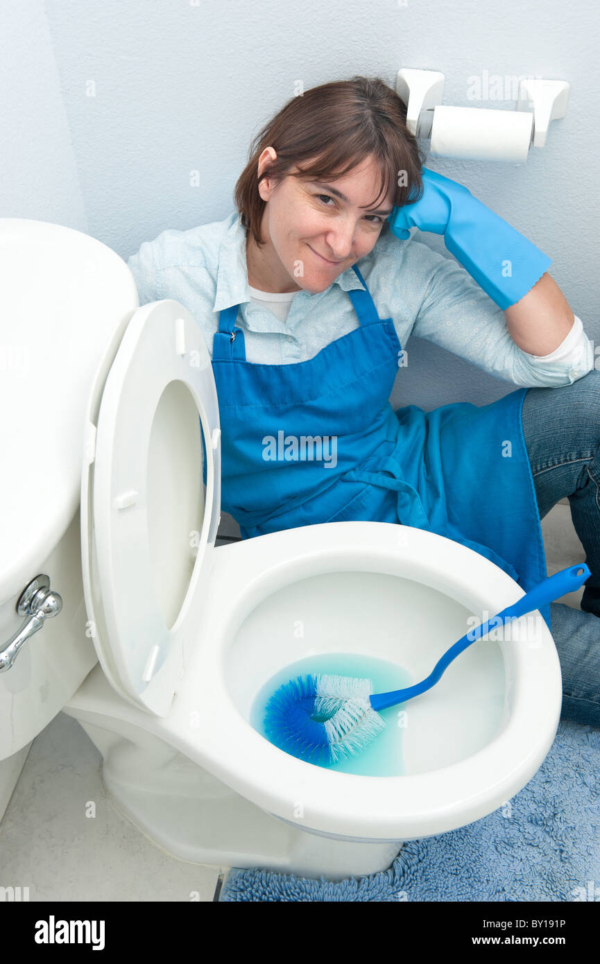 Eine Frau liegt keine Motivation, die Toilette in ihrem Haus zu reinigen. Stockfoto