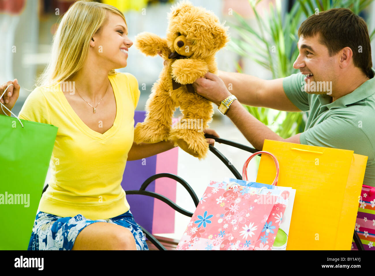 Porträt von glücklicher Mensch einen Teddybären zu ihrer Freundin im Shop geben Stockfoto