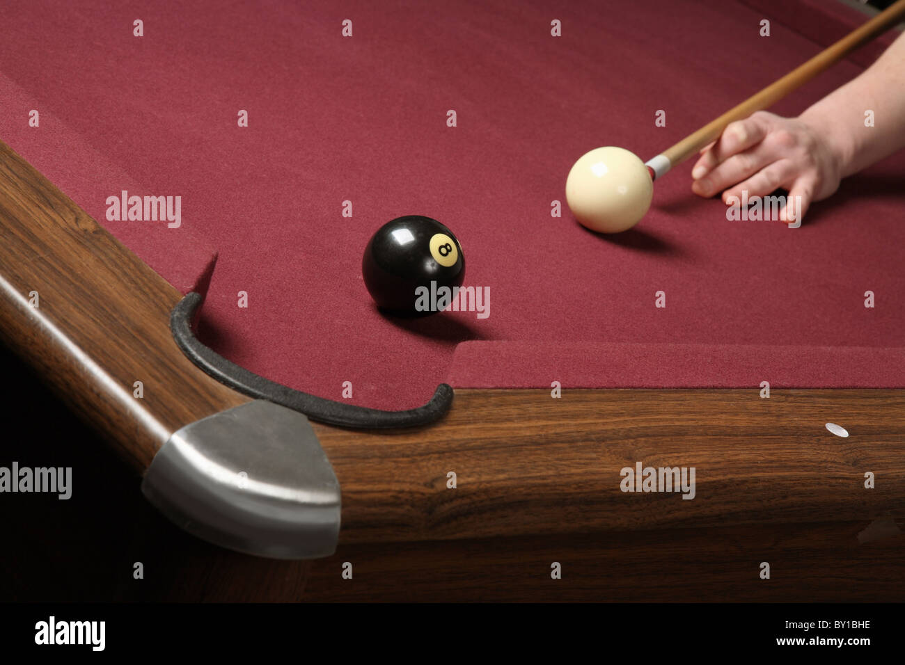 Poolspieler Schlange stehen Queue und acht Ball bereit, um gewinnende Schuss in Billard-Tasche schießen Stockfoto