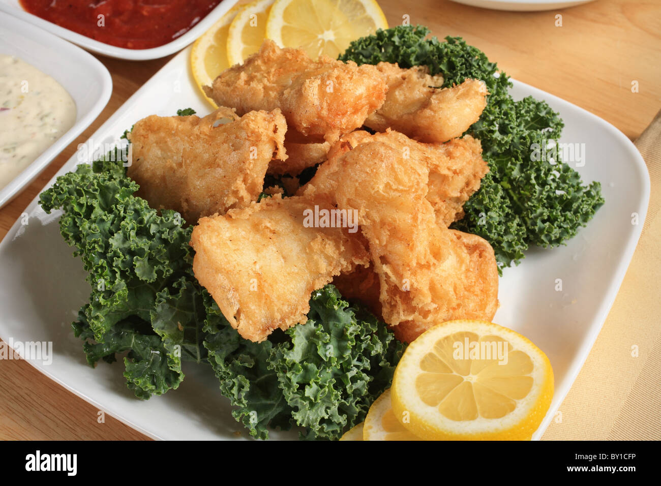 gebratenen Fisch Gericht Nahaufnahme mit Sauce und Zitrone Stockfoto