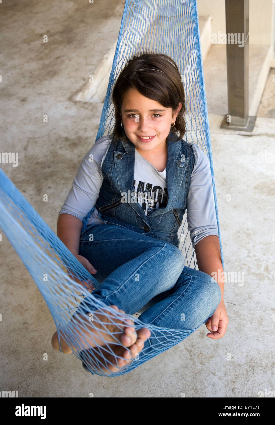 Mädchen in Hängematte tragen Jeans Stockfoto