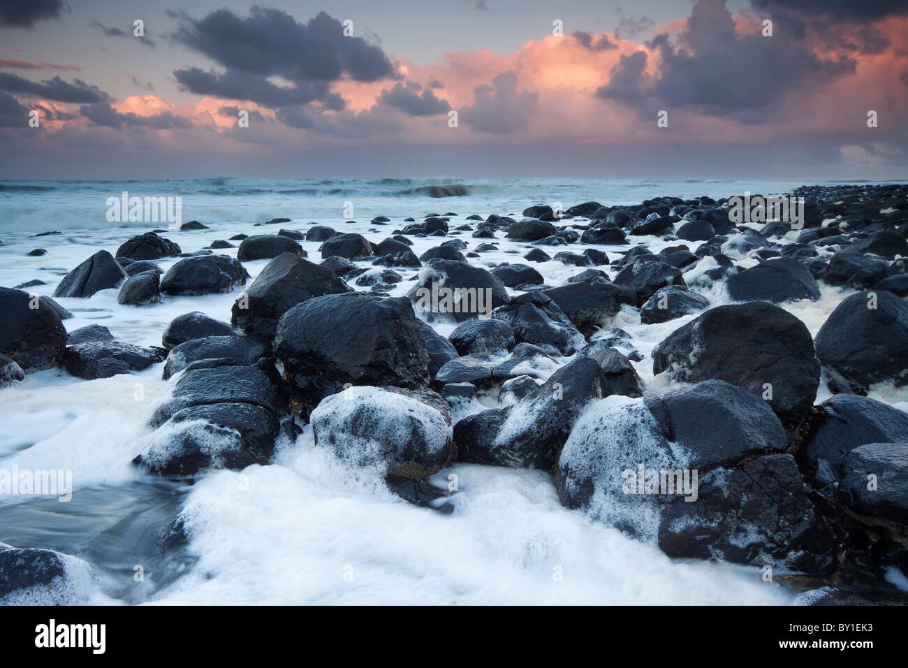 Ozean voller Schaum in der Dämmerung mit interessanten Wolkenbildung Stockfoto