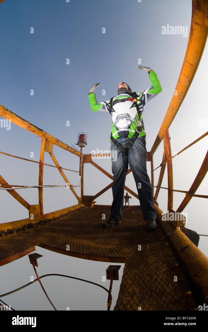 Ein Mann auf einem Metallplattform über eine Funkantenne kurz vor seiner BASE-Jump. Stockfoto