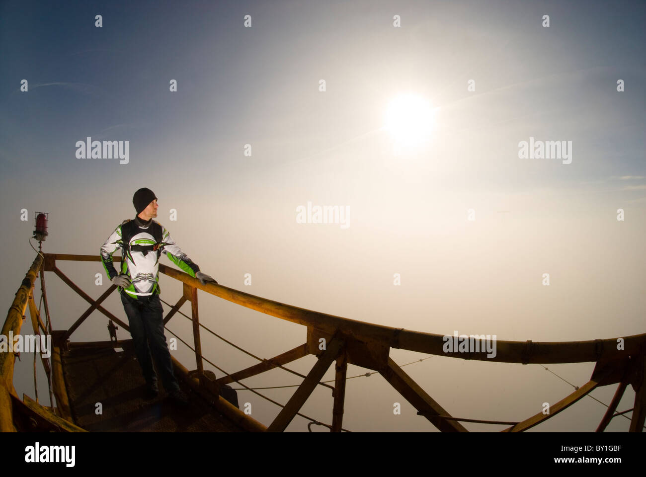 Ein Mann auf einem Metallplattform über eine Funkantenne kurz vor seiner BASE-Jump. Stockfoto