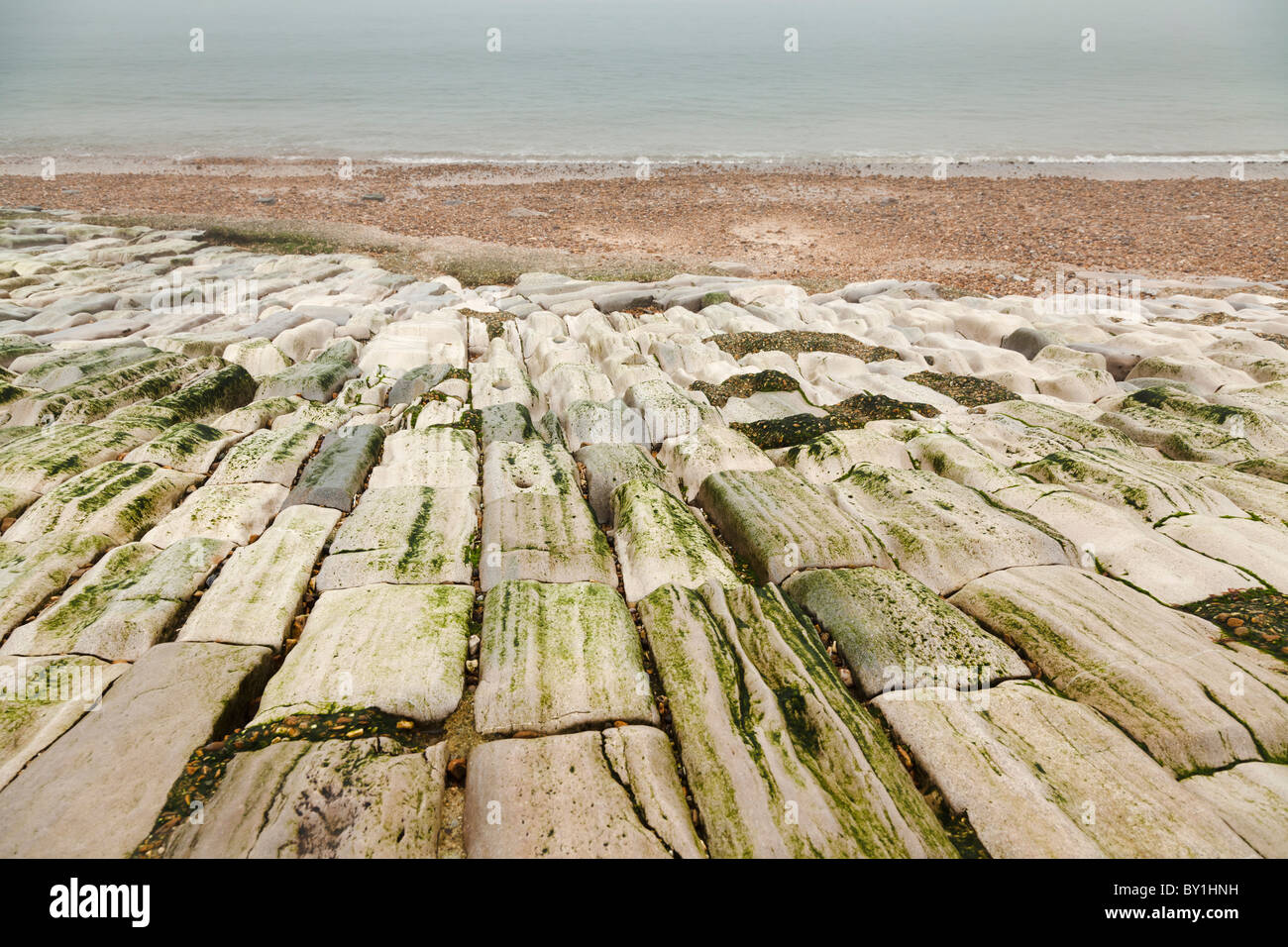 Meer-Verteidigung legte Steinen am Strand abgenutzt durch die Einwirkung von Wasser Stockfoto