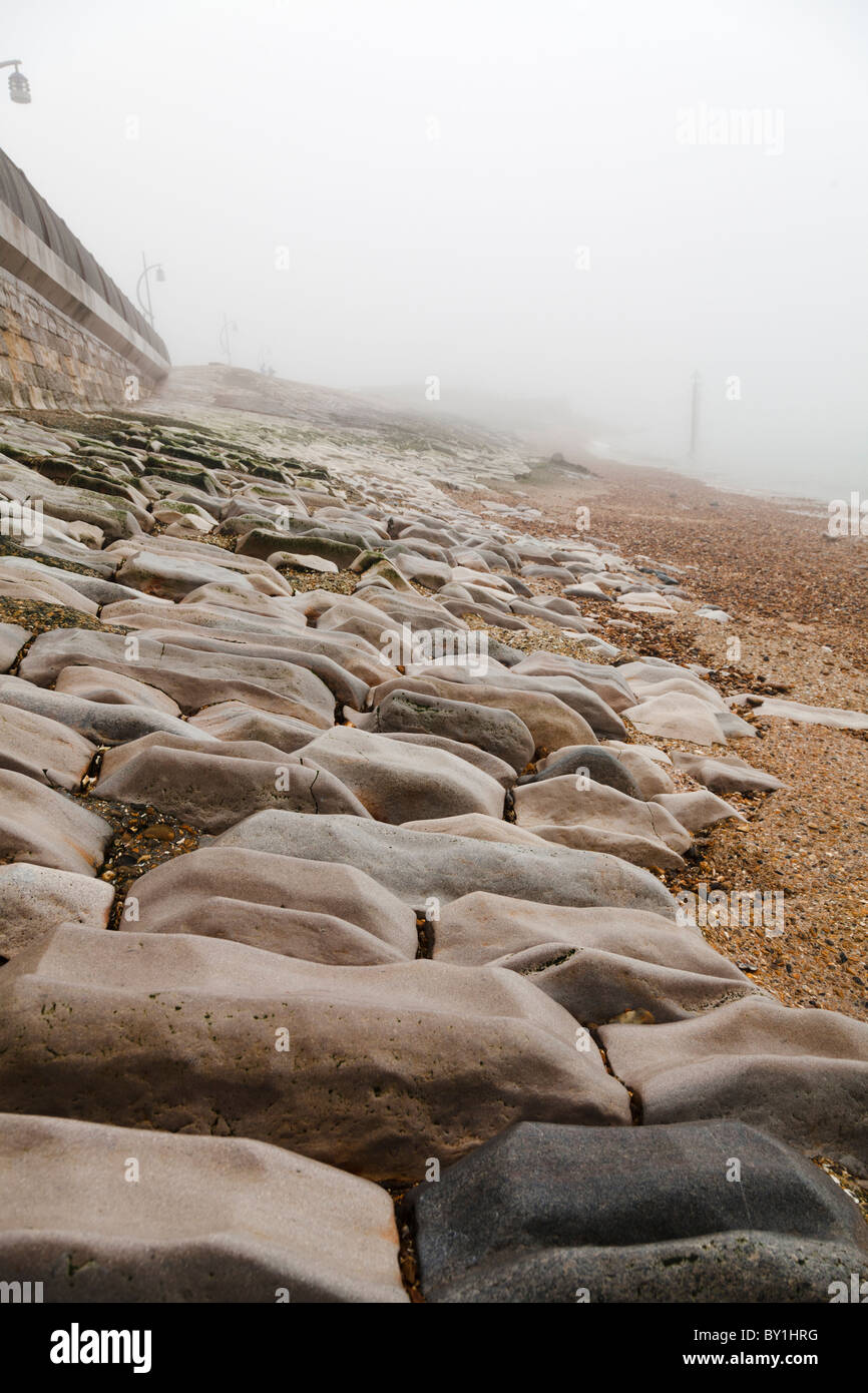 Meer-Verteidigung legte Steinen am Strand abgenutzt durch die Einwirkung von Wasser Stockfoto