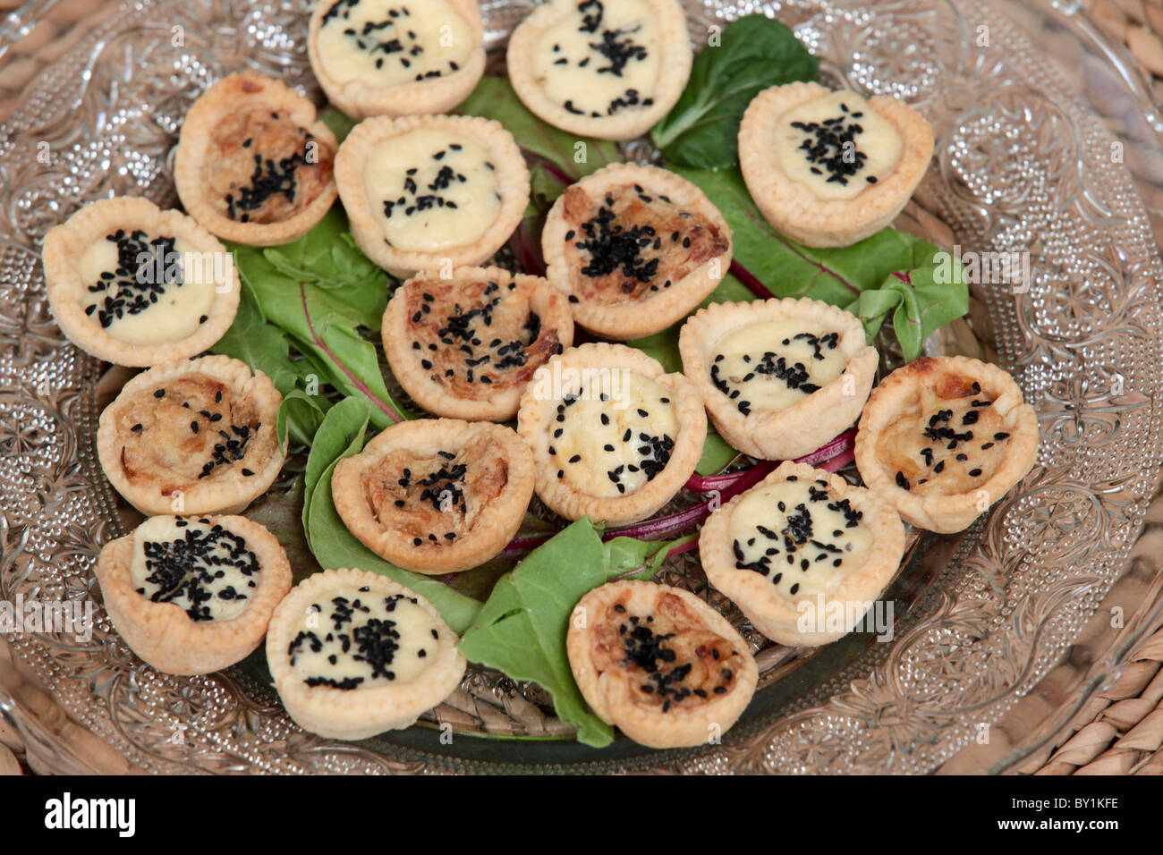 Ein Teller mit herzhaften Tartelettes (kleine Törtchen mit verschiedenen pikanten Füllungen) Stockfoto